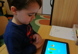 Chłopiec pracuje z tabletem.