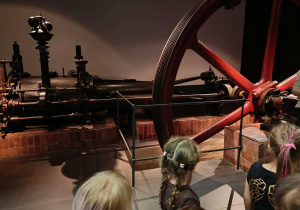 Dzieci oglądają eksponaty w muzeum.