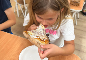 Dziewczynka je pizzę.
