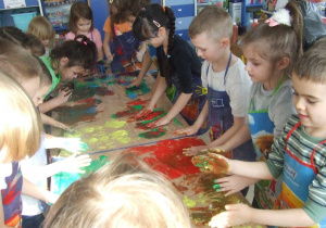 Dzieci malują całą dłonią.