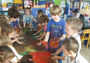 Dzieci malują całą dłonią.