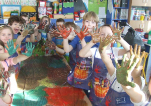 Dzieci pokazują pomalowane swoje ręce.