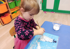 Dziewczynka maluje po foli bąbelkowej zimowy obrazek