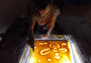 Chłopiec rysuje na panelu swietlnym