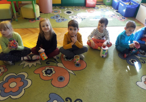 Dzieci grają na bębenkach wykonanych z puszek.