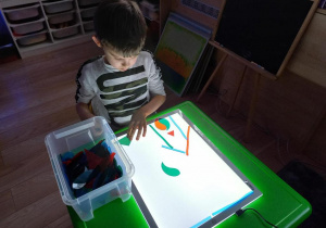 Dziecko układa na panelu świetlnym