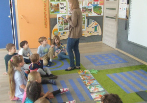 Nauczycielka wyjaśnia dzieciom działanie kodów QR.