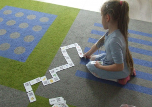 Dziewczynka gra w domino z użyciem kodów QR.