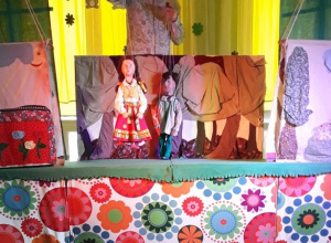 Dzieci oglądają przedstawienie w teatrzyku kukiełkowym.