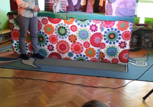 Dzieci oglądają przedstawienie w teatrzyku kukiełkowym.