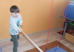 Chłopiec ciągnie linę.