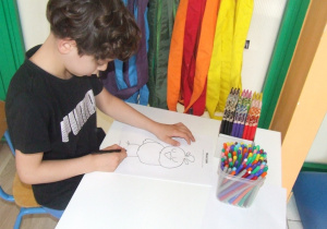 Chłopiec rysuje drugą symetryczną połowę obrazka.