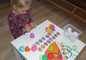 Dziewczynka składa plastikowe jajka wg wzoru.