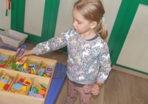 Dziewczynka układa wzory na szablonach jajek z klocków