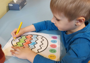 Chłopiec koloruje pisanke