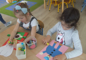 Dzieci wykonują pracę plastyczną techniką origami.
