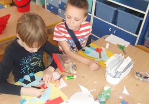 Dzieci wykonują pracę plastyczną techniką origami.
