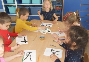 Dzieci malują chińskie znaki.