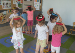 Dzieci ćwiczą równowagę z kółkami ringo.
