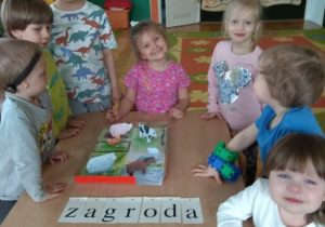 Dzieci prezentują zrobioną zagrodę dla zwierząt.