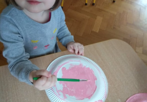 Dziewczynka maluje świnkę.