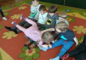 Dzieci czołgają się po nogach kolegów z grupy.