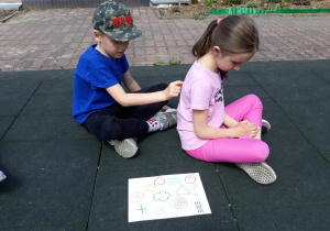Dzieci rysują palcem symboliczne obrazki.