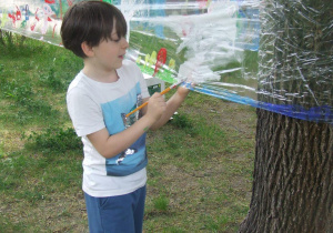 Chłopiec maluje na streczu "Łąka"