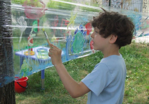 Chłopiec maluje na streczu "Łąka"