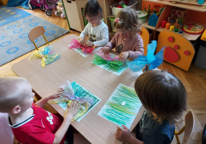Dzieci robią kolorowe motyle.