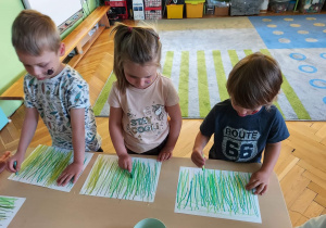 Dzieci rysują kreski.