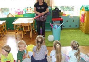 Nauczycielka tworzy pieska z balonów.