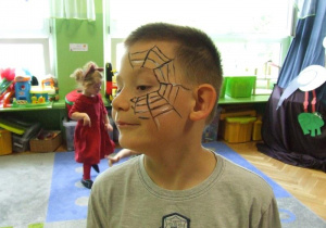 Chłopiec prezentuje wymalowaną twarz.
