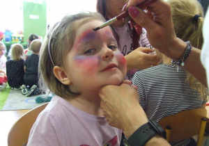Dziewczynka ma malowaną twarz.