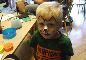 Chłopiec prezentuje wymalowaną twarz.