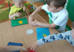 Dzieci wyklejają obrazek masą piankową