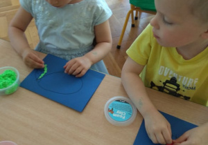 Dzieci wyklejają obrazek masą piankową