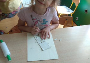 Dzieci wykrawają obrazki z gliny.