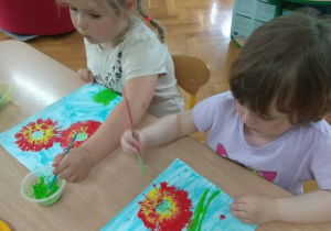 Dzieci stemplują rolką kwiaty.