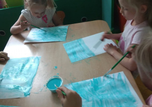 Dzieci malują tło.