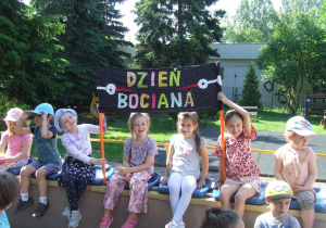 Dzieci trzymają transparent z napisem "Dzień bociana".