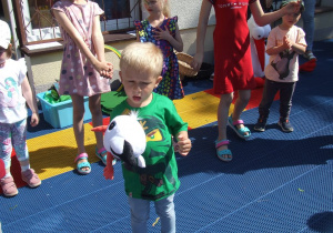 Chłopiec trzyma maskotkę bociana.