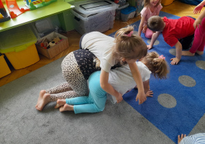 Dziewczynki wykonują ćwiczenia w trójkach.