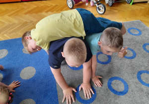 Chłopcy wykonują ćwiczenia w trójkach.
