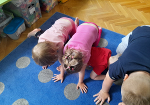 Dzieci wykonują ćwiczenia w trójkach.