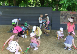 Dzieci wykopują szkielet dinozaura.