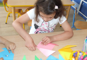 Dziewczynka składa origami.