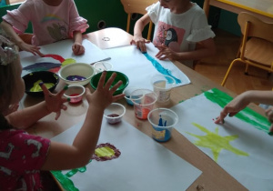 Dzieci malują farbami.