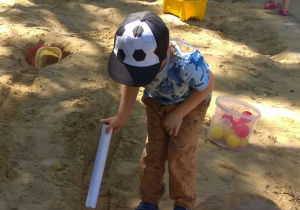 Chłopiec turla piłkę przez wyznaczoną ścieżkę.