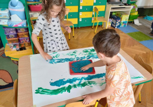 Dzieci malują rękoma.